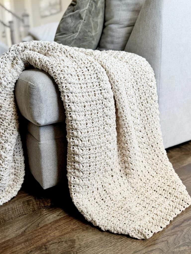 cream crochet throw draped over end of couch