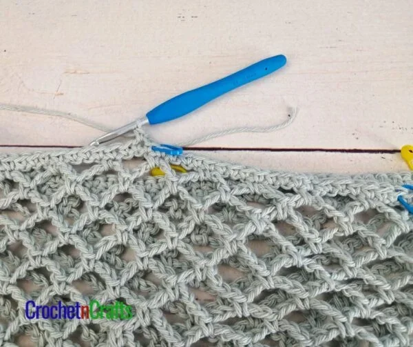 Join yarn to the left of the stitch marker on the left, leaving the 20 stitches in the middle unworked.