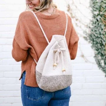 Woman wearing a cotton crochet backpack with a drawstring.