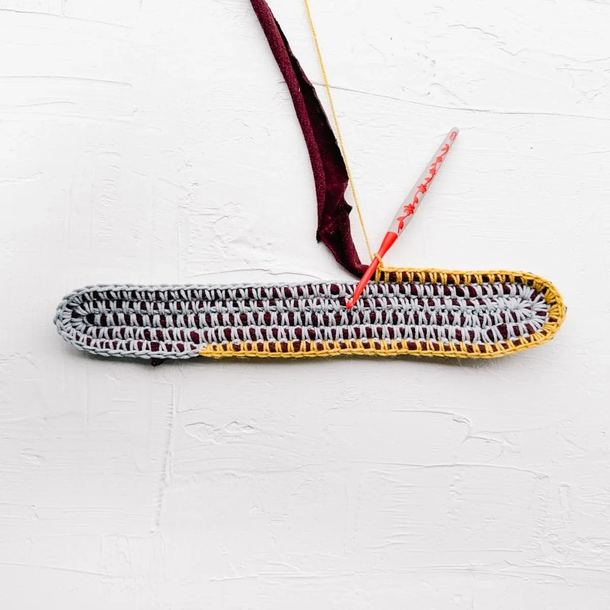Crocheted oval bag base with t-shirt yarn at the core.