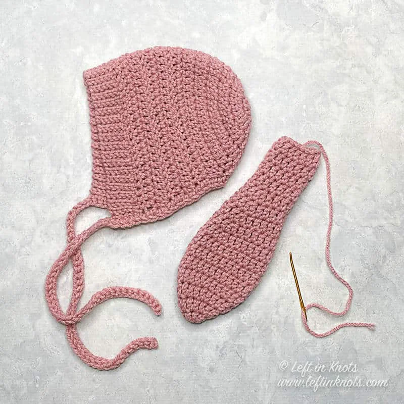 A crochet bunny bonnet with an ear piece that isn't attached yet