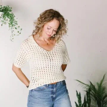 Jess Coppom wearing a white crocheted tee with a collar.