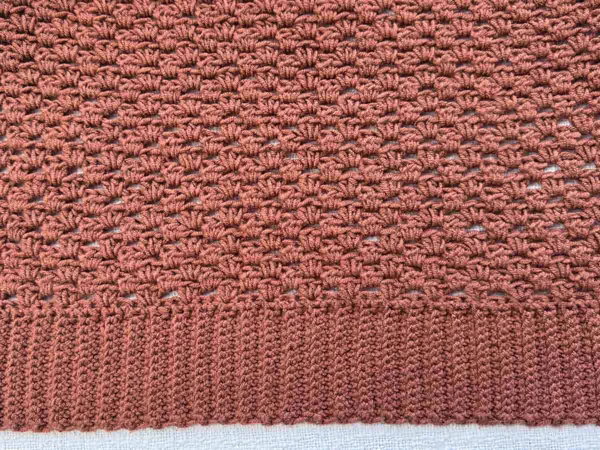 Close-up of the half double crochet stitch texture in rust-toned Lion Brand Color Theory yarn.