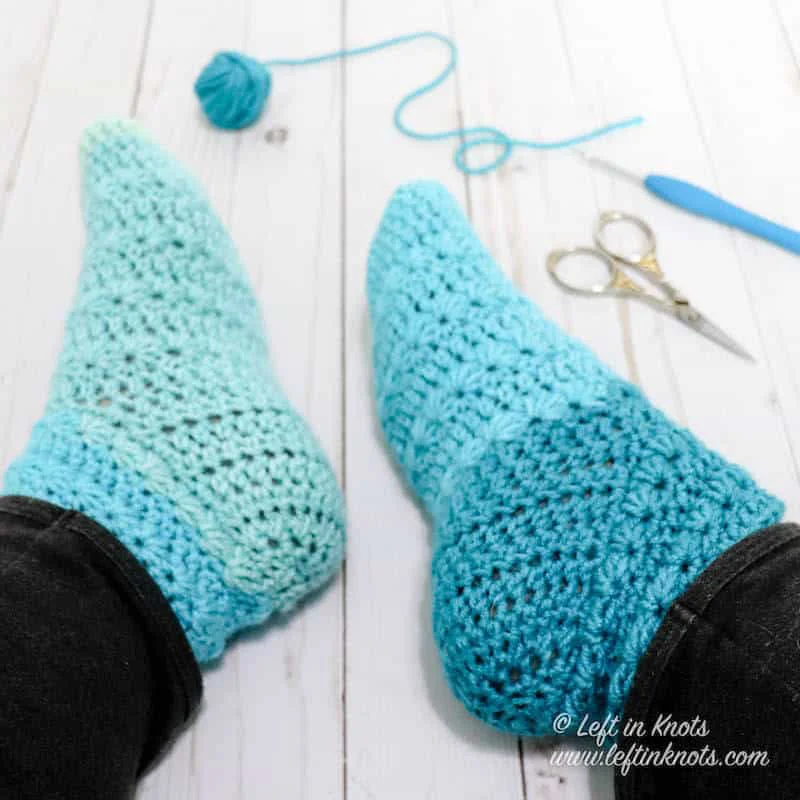 A pair of crochet slipper socks made with Caron Cakes yarn and the star stitch