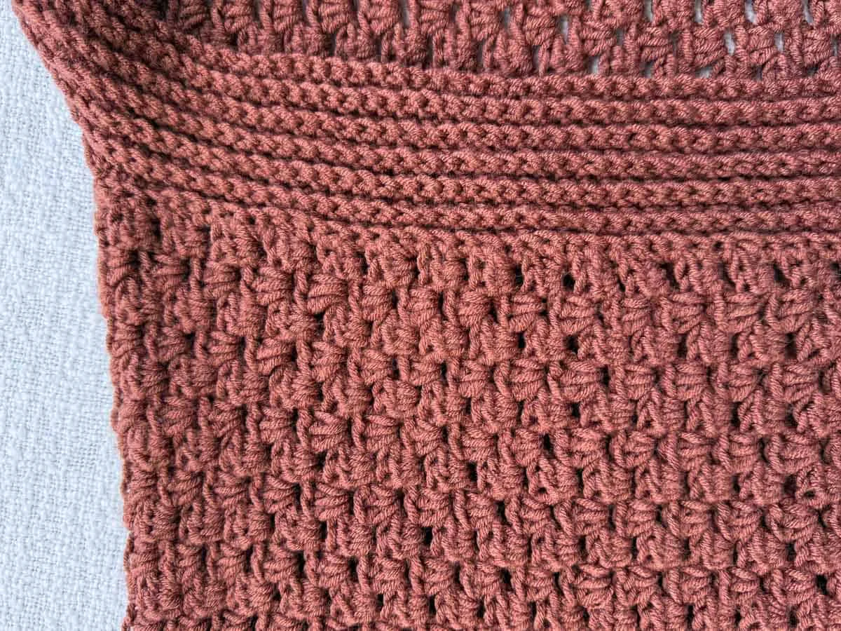 Detail shot showing the ribbed collar transitioning into the half double crochet body of the cardigan.