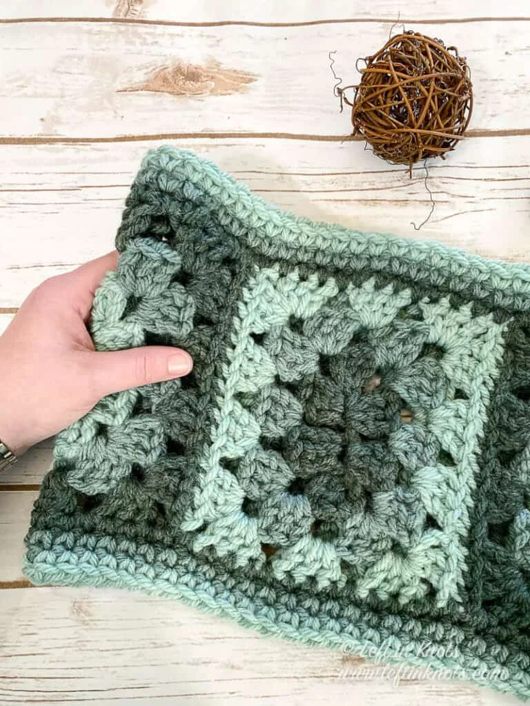 A crochet cowl made with granny rectangles in shades of green