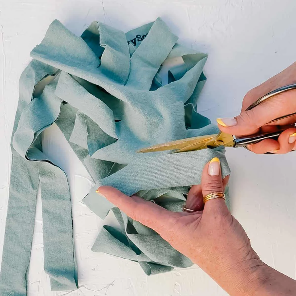 A t-shirt being cut into a long strand of t-shirt yarn.
