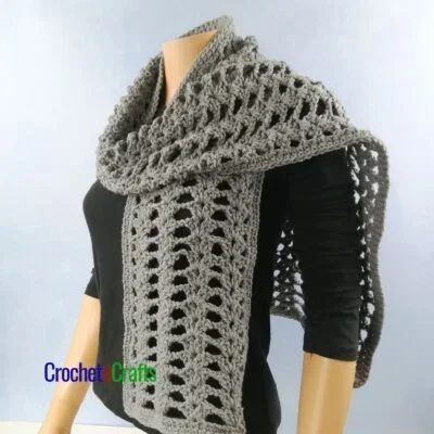 Lacy crochet scarf wrapped around a mannequin.