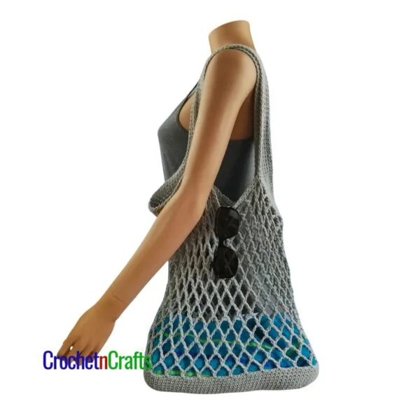 Crochet Mesh Bag Pattern Draped over the shoulders of a Mannequin.