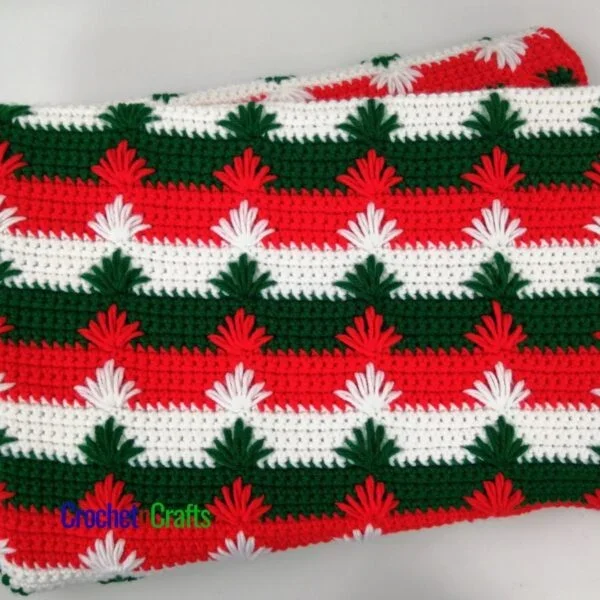 Puffy spike stitch crochet blanket pattern shown in three Christmas colors.