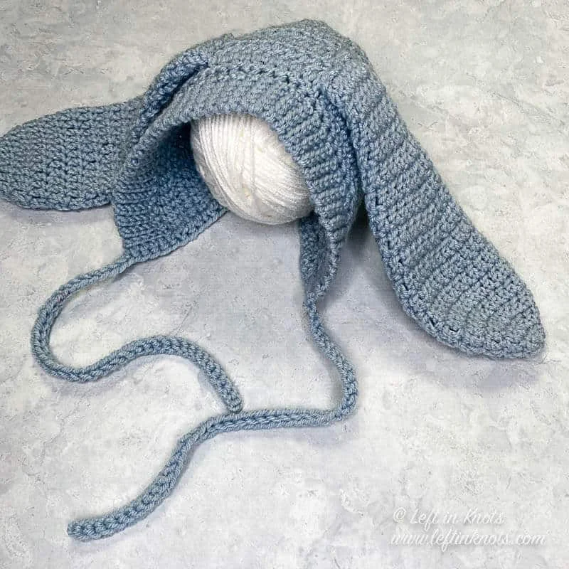A blue crocheted bunny bonnet made for a baby