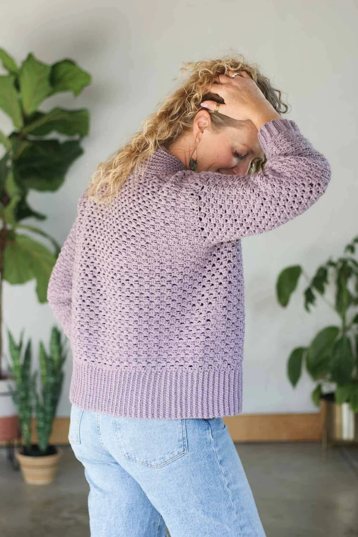 Side view of a purple, lightweight crochet cardigan with single crochet ribbing along the bottom edge.