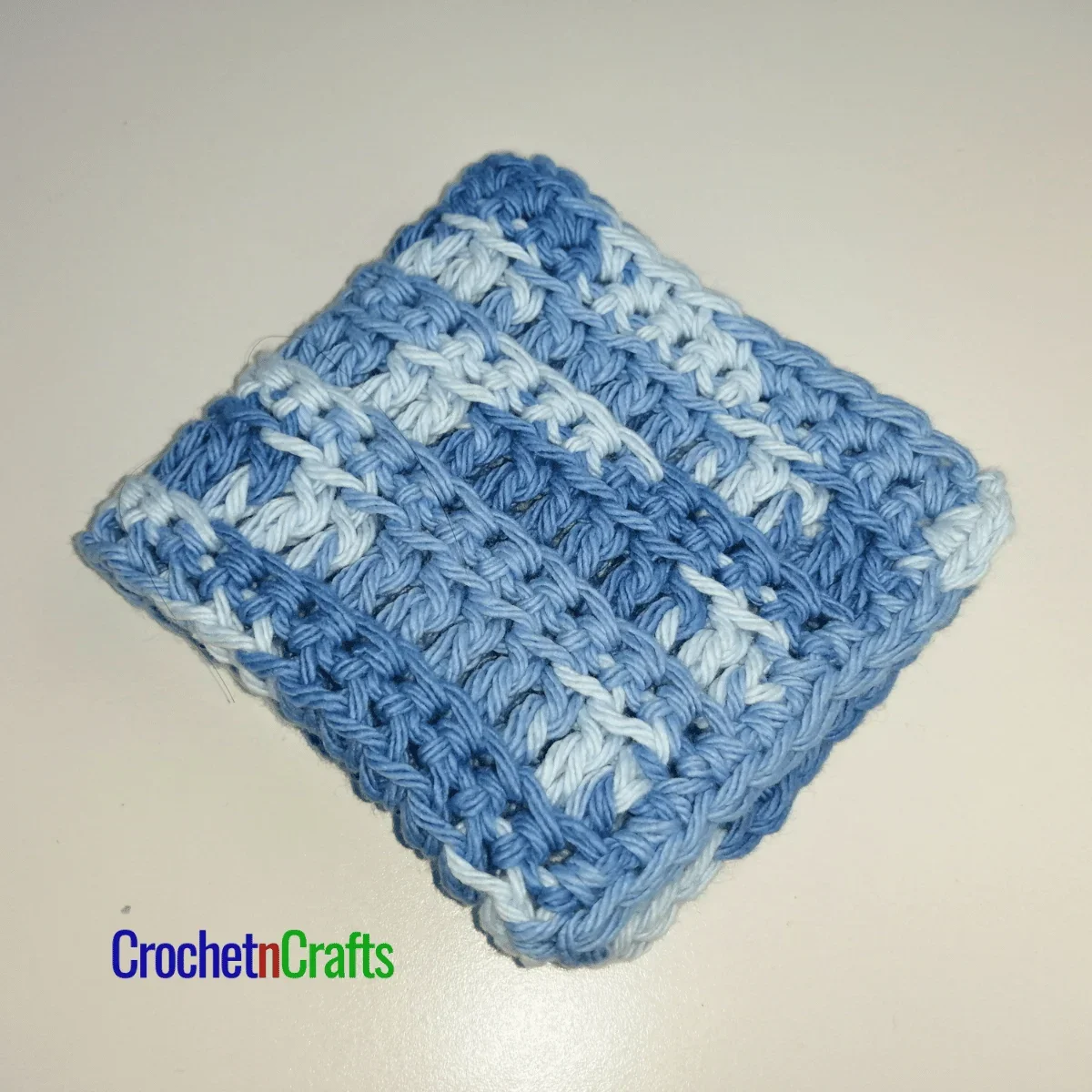 Crochet ribbed dishcloth folded up.