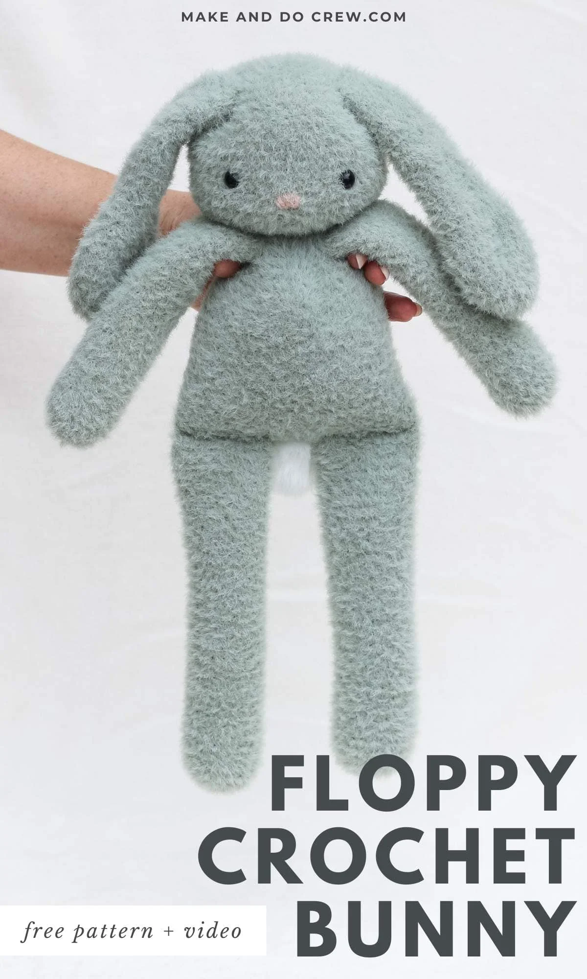 A long-legged crochet bunny held in a woman's hand.