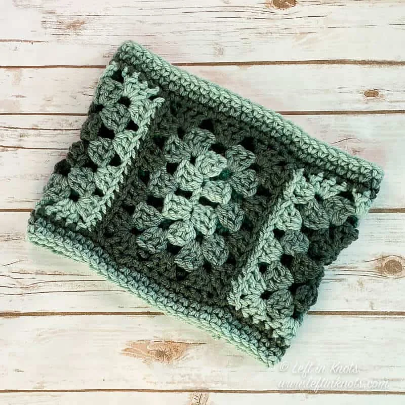 A crochet cowl made with granny rectangles in shades of green