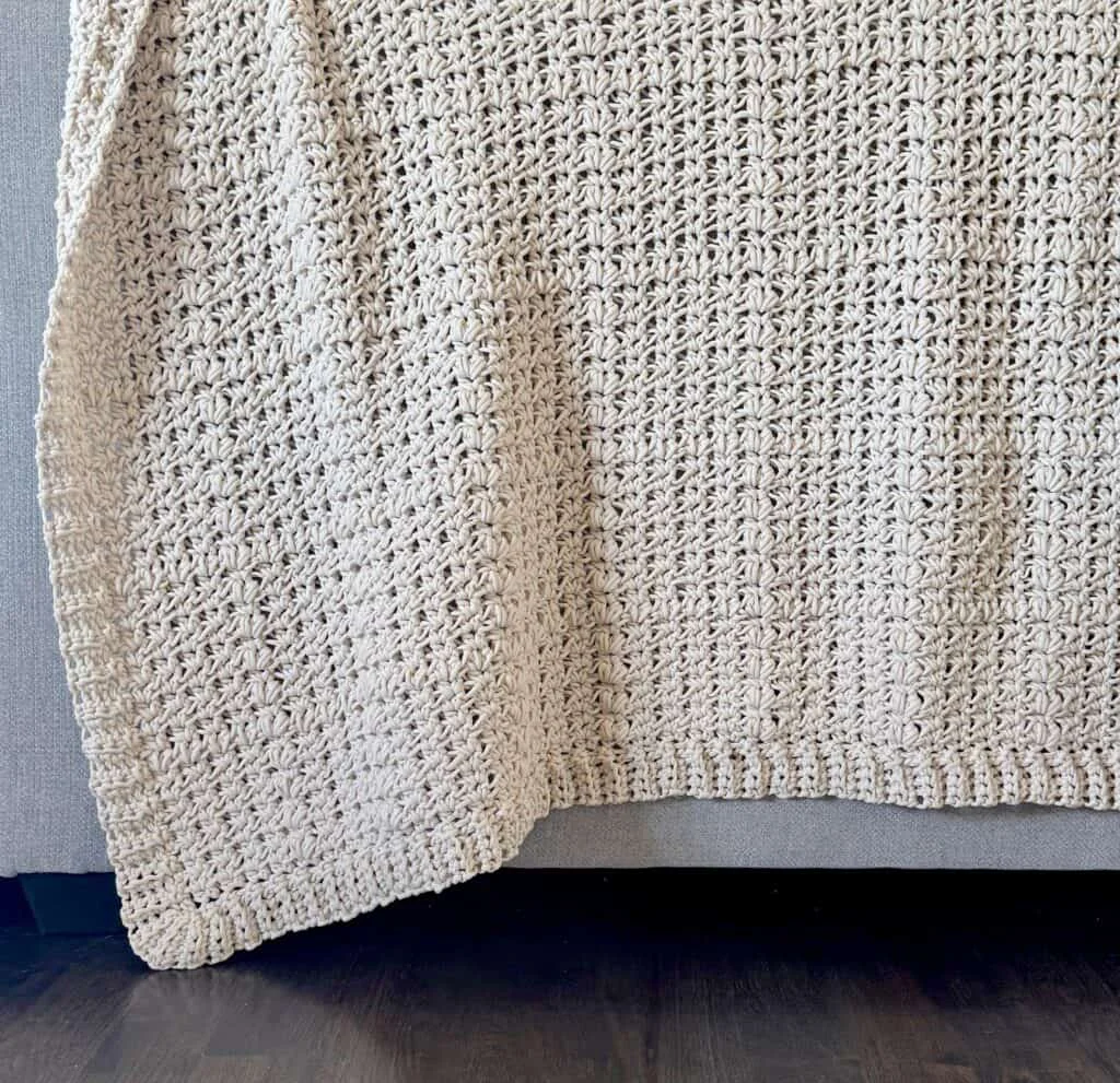 cream crochet blanket draped over couch