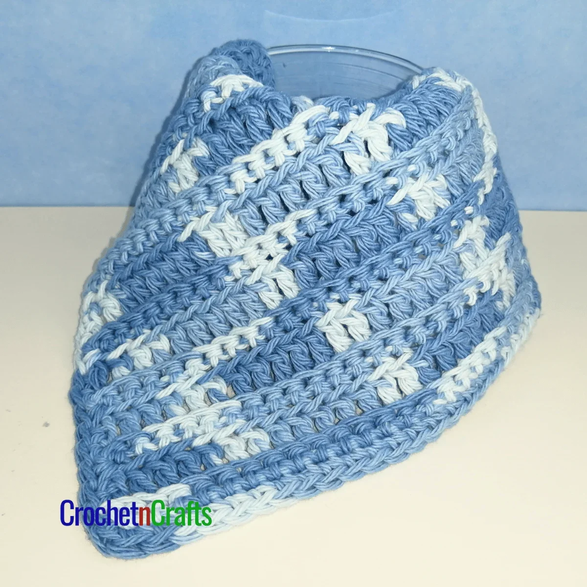 Crochet ribbed dishcloth draped over a glass.